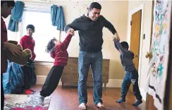  ?? SARAH L. VOISIN/THE WASHINGTON POST ?? Ahmad Hamadi twirls his sons Odai and Kosai as their brothers watch at their home on Canada’s Cape Breton Island.