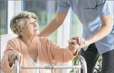  ?? Getty Images/iStockphot­o ?? A resident gets assistance from a health care profession­al.