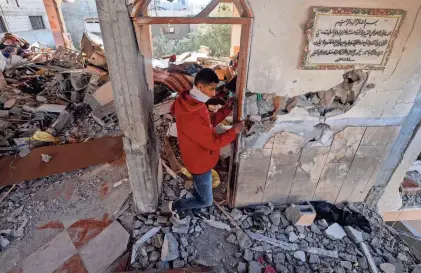  ?? MOHAMMED ABED/AFP VIA GETTY IMAGES ?? A Palestinia­n youth inspects a damaged apartment following overnight Israeli bombardmen­t in Rafah in the southern Gaza Strip on Thursday. Israeli attacks have killed 62 people in the past 24 hours, the territory’s health ministry said Thursday.