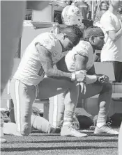  ?? JIM ROGASH/GETTY ?? The Dolphins’ Kenny Stills, left, and Albert Wilson kneel during the national anthem prior to the game against the Patriots at Gillette Stadium.