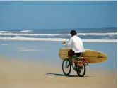  ??  ?? TOP: The St. Augustine skyline from the Bridge of Lions. CENTER: A surfer on St. Augustine Beach.