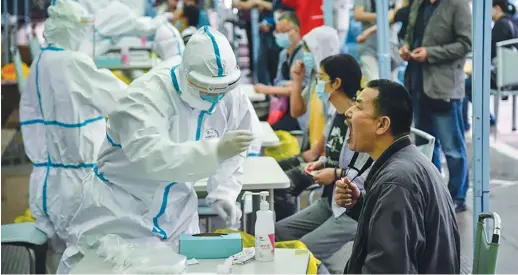  ?? AFP PHOTO ?? SAY AHH
Medical workers conduct mass coronaviru­s tests in the city of Wuhan in China’s central Hubei province.