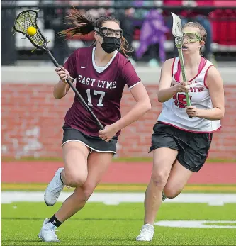  ?? SARAH GORDON/THE DAY ?? East Lyme´s Caroline Real (17) moves past NFA´s Alice Rourke (15) during Tuesday’s ECC girls’ lacrosse game in Norwich. The Vikings won 21-2. Visit www.theday.com to view a photo gallery.