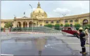  ??  ?? A firefighte­r sprays disinfecta­nt on a street in front of UP Vidhan Sabha, during the total lockdown imposed by the state government due to surge in Covid-19 cases, in Lucknow, on Saturday