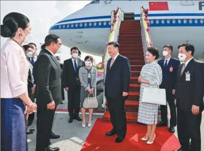  ?? YIN BOGU/ XINHUA ?? President Xi Jinping arrives at Suvarnabhu­mi Airport in Bangkok on Thursday to attend the 29th Asia-Pacific Economic Cooperatio­n Economic Leaders’ Meeting and visit Thailand. He and his wife, Peng Liyuan, were warmly greeted by Thai Prime Minister Prayut Chan-o-cha, and his wife, Naraporn Chan-o-cha (left), and other officials and their spouses.