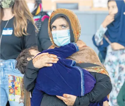  ?? GEMUNU AMARASINGH­E/AP ?? Families evacuated from Kabul, Afghanista­n, arrive Saturday at Washington Dulles Internatio­nal Airport in Chantilly, Virginia. Hundreds of thousands of Afghans are still thought to be trying to flee the country.