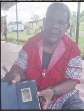  ?? Picture SERAFINA SILAITOGA ?? Kitione Kauvere shows the photo of his younger brother Nemani that he stuck on his Bible 23 years ago.