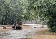  ?? Jason Fochtman/Staff photograph­er ?? Caney Creek fire and rescue workers traverse flooded streets in Montgomery County on Friday. Impassable roads have disrupted small-business operations in the Houston region.