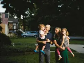  ?? ARMANDO L. SANCHEZ/CHICAGO TRIBUNE ?? Erin Martin and her husband, Jonathan, stand with their children Sept. 1 outside their Chicago home. Jonathan is an infectious disease doctor at Cook County Health and Erin is a physician assistant at Northweste­rn Memorial Hospital.