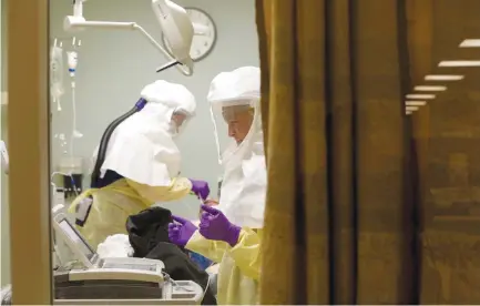  ?? (Nelvin C. Cepeda/San Diego Union-Tribune/TNS) ?? NURSES IN personal protective equipment treat a patient diagnosed with COVID-19 in an isolation room at San Diego’s Sharp Memorial Hospital’s Emergency Department last month.