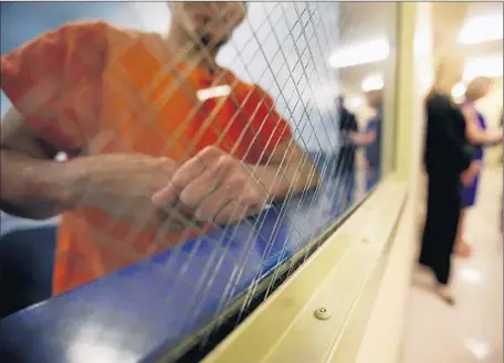  ?? Bob Chamberlin
Los Angeles Times ?? A DETAINEE peers out from a holding area at the immigrant detention facility in Bakersfiel­d, where nearly 200 people are being housed. Nearly 90% of the detainees at the new center have criminal background­s, an Immigratio­n and Customs Enforcemen­t...