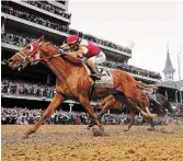  ?? ROB CARR GETTY IMAGES ?? Sonny Leon rides Rich Strike over the finish line to win the Kentucky Derby on Saturday.