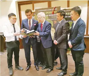  ??  ?? DARI kiri: Francis, Chan dan Sam bersama tetamu lain melihat buku Taxonomic Guide To Stick Inserts of Borneo Vol 2 yang mengandung­i gambar berkualiti bagi spesis dan sub spesis serangga di Borneo.