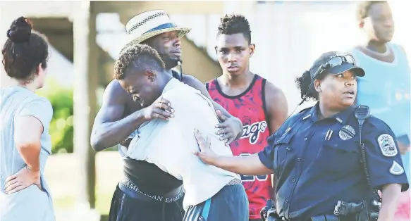  ?? PHOTOS BY KINFAY MOROTI, USA TODAY NETWORK ?? People comfort one another outside Club Blu in Fort Myers, where two young men were killed and as many as 16 other people were injured early Monday.