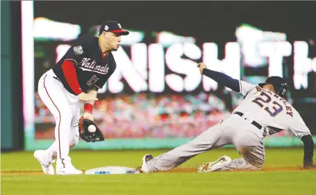  ?? PATRICK SMITH/GETTY IMAGES ?? Washington infielder Asdrubal Cabrera corrals the ball as Houston Astros outfielder Michael Brantley steals second base during Game 3 of the World Series on Friday night at Nationals Park. The Astros were looking to rebound after dropping the first two games.