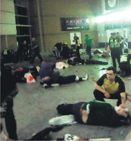  ??  ?? Emergency workers and helpers treat the injured in the foyer of the Manchester Arena.