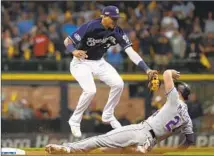  ?? Jeff Roberson Associated Press ?? MILWAUKEE SHORTSTOP Orlando Arcia tags out Colorado’s Ryan McMahon on an attempted steal of second base.