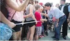  ?? DARRYL DYCK/THE CANADIAN PRESS ?? Prime Minister Justin Trudeau greets people in the crowd during a stop at B.C. Day celebratio­ns in Penticton on Monday during a long-weekend visit to the province.