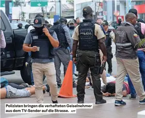  ?? AFP ?? Polizisten bringen die verhaftete­n Geiselnehm­er aus dem Tv-sender auf die strasse.