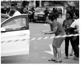  ??  ?? A relative cries out in agony as she looks at the body of Evaldo dos Santos Rosa slumped over inside his car in the Guadalupe neighbourh­ood, Rio de Janeiro, Brazil, on Sunday. Authoritie­s say soldiers mistook the car driven by Santos Rosa for that of criminals and fired 80 shots at it.