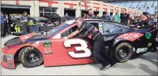  ?? Paul Abell / AP ?? NASCAR driver Austin Dillon’s car is pushed into the garage by crew members during practice for today’s NSCAR race at Atlanta Motor Speedway.