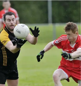  ??  ?? Mark Gordon of Enniscrone/ Kilglass in possession as Ballymote’s Stephen Ross chases during their Division 3 match in Corran Park on Sunday afternoon. Pic: Carl Brennan.