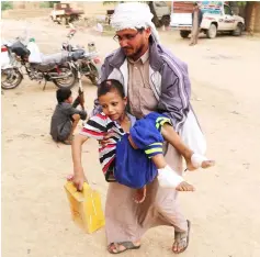  ??  ?? Abdulwahab Ali carries his nephew,Yahya Muhammad, who survived last month’s air strike that killed dozens of people including children, in Saada, Yemen. — Reuters photo