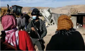  ?? Photograph: APAImages/REX/Shuttersto­ck ?? Palestinia­ns gather in front of Israeli forces as an Israeli machinery demolishes a Palestinia­n structure in January 2022