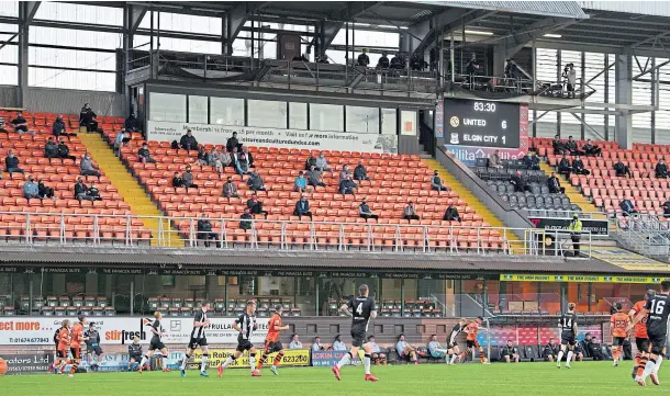  ?? ?? LUCKY FEW: A scattering of fans watch from the stands at Tannadice as Dundee United play Elgin after the partial lifting of Covid restrictio­ns in July.