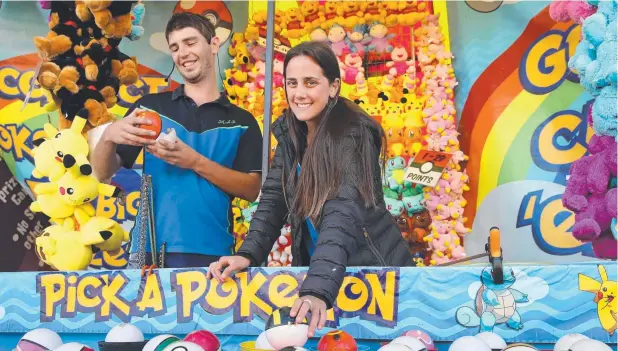  ?? Picture: ANNA ROGERS ?? FUN TIMES: Sideshow alley workers Lewis Arthur from Wales and Julieta Laccone from Argentina working at the Pokemon stall at the Atherton Show