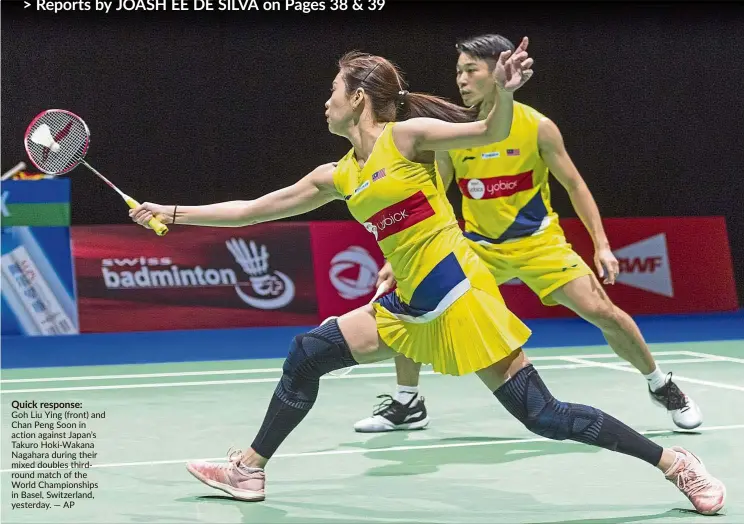  ?? — AP ?? Quick response:
Goh Liu Ying (front) and Chan Peng Soon in action against Japan’s Takuro Hoki-Wakana Nagahara during their mixed doubles thirdround match of the World Championsh­ips in Basel, Switzerlan­d, yesterday.