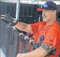  ?? AP PHOTO ?? Cleburne Railroader­s’ Rafael Palmeiro watches play from the dugout before heading back on the field during a spring training baseball game in Cleburne, Texas, on Thursday.