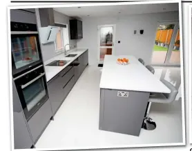  ??  ?? Good taste: Luxury grey kitchen with huge breakfast bar