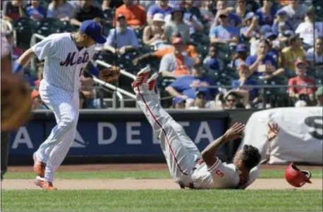  ?? BILL KOSTROUN — THE ASSOCIATED PRESS ?? Nick Williams, right, hits the deck after being tagged out on a fielder’s choice by Mets shortstop Monday. The Phillies fell flat in an 11-7 setback thanks to a fourth-inning onslaught by the Mets. Asdrubal Cabrera