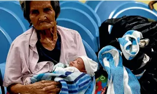  ?? PHOTO: REUTERS ?? A woman carries a baby at an evacuation centre for victims of Typhoon Haima in San Fernando, la Union in northern Philippine­s.