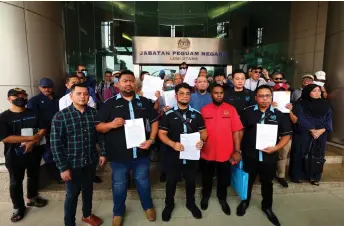  ?? — Bernama photo ?? Hishamuddi­n (front, centre) and others from MHO pose with the investment scam victims at the Attorney-General’s Chambers.