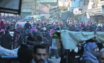  ?? Abdalrhman Ismail / Reuters ?? People gather to be evacuated from Al Sukkari, a rebel-held sector of eastern Aleppo, Syria.