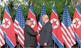  ?? AP ?? US President Donald Trump and North Korean leader Kim Jong Un shake hands at the Capella Hotel in Singapore yesterday.