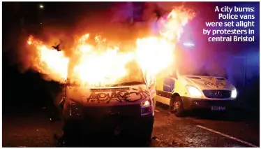  ??  ?? A city burns: Police vans were set alight by protesters in central Bristol