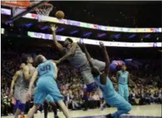  ?? MATT SLOCUM — THE ASSOCIATED PRESS ?? Joel Embiid, center, gets off against Charlotte’s Michael Kidd-Gilchrist, right, and Cody Zeller during the second half Friday. ‘Clutch’ helped the 76ers pull out a 133-132 victory in overtime.