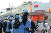  ?? PHOTOS BY MO XIAOLIANG / FOR CHINA DAILY AND ZHANG KAI / FOR CHINA DAILY ?? Left: Carrier-based J-15 fighters prepare to take off from aircraft carrier CNS Liaoning in a drill in the Bohai Sea. Top: Crew members train as cold winds sweep the carrier deck.