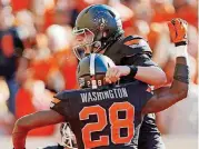 ?? [PHOTO BY NATE BILLINGS, ?? Oklahoma State quarterbac­k Mason Rudolph and wide receiver James Washington celebrate a touchdown during a recent game at Boone Pickens Stadium.