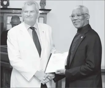  ??  ?? Lt Col (rtd) Russell Combe (at left) handing over the plan to President David Granger in January