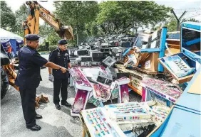  ?? SHAHRILL BASRI / THE SUN ?? Mazlan (right) and Petaling Jaya district police chief ACP Mohd Zani Che Din looking at the computer units that were disposed yesterday.
