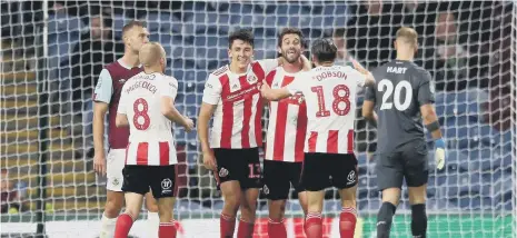  ??  ?? Sunderland players celebrate with Will Grigg at Turf Moor.