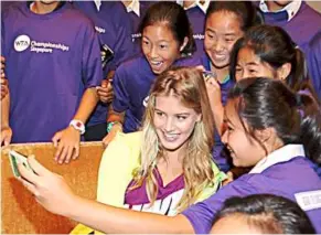  ??  ?? bouchard taking a photo with her young fans after sharing her experience as a profession­al tennis player in Singapore recently.