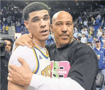  ?? RICHARD MACKSON, USA TODAY SPORTS ?? LaVar Ball embraces his son Lonzo after a UCLA game. Lonzo could be picked by the Lakers in next month’s draft.