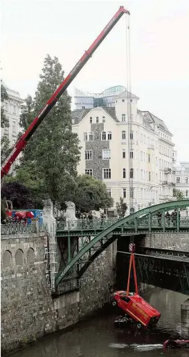  ??  ?? Mit einem Spezialkra­n wurden die Unfallfahr­zeuge der Baufirma nach dem Flut- Drama aus dem Wienfluss geholt.