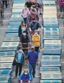  ?? DARRYL DYCK / THE CANADIAN PRESS VIA AP ?? Shoppers are separated by rows of wood pallets to help with social distancing as they line up to enter a Costco store in Burnaby, British Columbia, Canada, on Sunday.