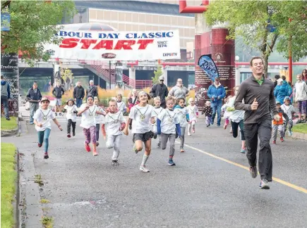  ?? CITIZEN PHOTO BY JAMES DOYLE ?? A group of kids take-off down Canada Games Way on Sunday morning while participat­ing in the Kids 1km Fun Run as part of the 45th annual Labour Day Classic foot race.